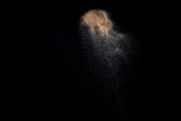 Sandy explosion isolated on black background. Abstract particles cloud. Texture element for design.