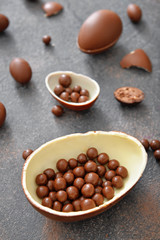 Chocolate eggs and candies on grey table