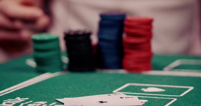 Close up of gambler throwing pocket rockets two aces on poker table shot in 4k super slow motion
