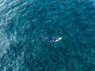 surfing instructor instructs you to ride the waves in the ocean top view shot from the air