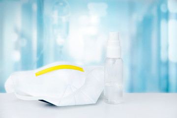 Mask and hand spray
 on the table background hospital