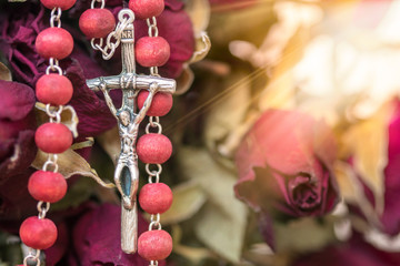 Catholic rosary and dry roses