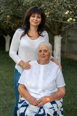 vertical close-up photo of a fifty year old woman with her ninety year old mother