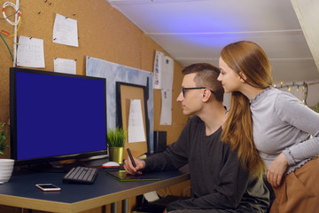 A couple with a dog are running. A man works on a graphic tablet with a dog in his arms, shows his girlfriend a computer, a green screen. A girl looks at how her boyfriend works at home. business