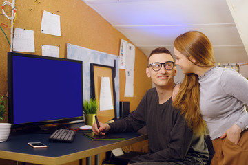 A couple with a dog are running. A man works on a graphic tablet with a dog in his arms, shows his girlfriend a computer, a green screen. A girl looks at how her boyfriend works at home. business