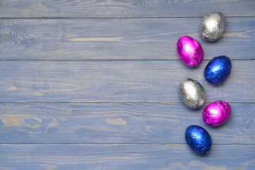 Sweet chocolate eggs on wooden background