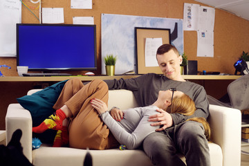 Obraz premium The couple is lying on the couch and talking. Lovers do nothing, spend a place together, laugh.
