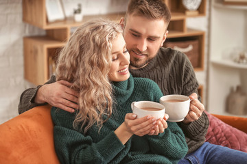 Happy young couple drinking hot cocoa at home