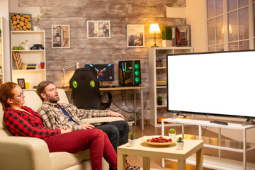 Couple looking at white isolated TV screen late at night in living room