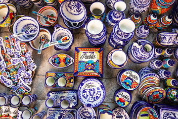Colorful traditional Mexican pottery. Talavera style. Souvenirs on sale in local market of Puebla,...