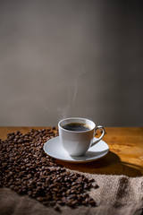 Cup of coffee and coffee beans on burlap sack.
Arrangement of coffee cup and coffee beans with copy space.