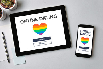 LGBT dating app concept on tablet and mobile phone screen over gray table. Gay online dating. Top view