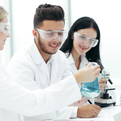 close up.a team of scientists sitting at the laboratory table