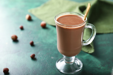 Cup of hot chocolate on color background