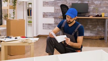 Confused furniture assembly worker while reading instructions