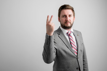 Portrait of business man wearing business clothes showing number two