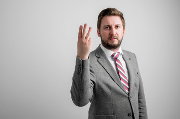 Portrait of business man wearing business clothes showing number three