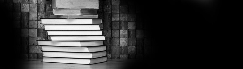 books on wooden table, black and white background