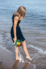 girl with a bouquet on the beach
