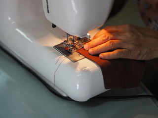 Work at home woman sitting sewing a fabric mask, for dust and germs pm 2.5, virus covid 19