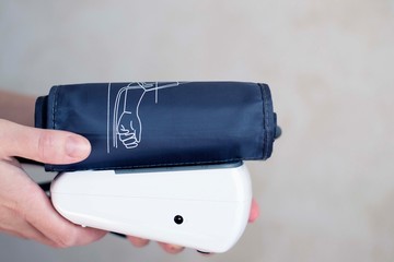 The device for independent measurement of blood pressure. Health in quarantine. Home tonometer. Close up. Hand with tonometer.