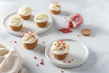 Homemade cupcakes with cream cheese and dries strawberry on white background. Party, happy birthday, pastry, bakery, cookbook recipe concept. Side view, close up