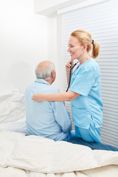 Krankenpfleger hört Patient mit Stethoskop ab
