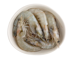Fresh Vannamei shrimps, whiteleg shrimp, Pacific white shrimp or king prawn in white bowl isolated on white. Top view, close-up.