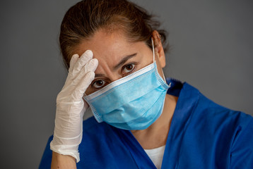 Female doctor feeling exhausted after long shift treating coronavirus infected patients at hospital