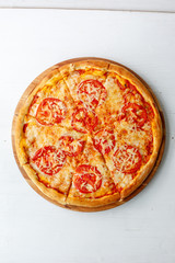 Italian pizza with tomatoes on a wooden background