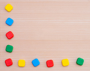 Various multi-colored geometric shapes on a wooden background. View from above. Background for text. Copy space