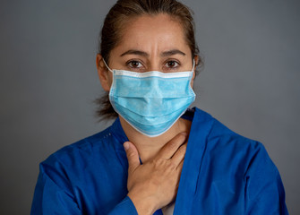 Female doctor feeling exhausted after long shift treating coronavirus infected patients at hospital