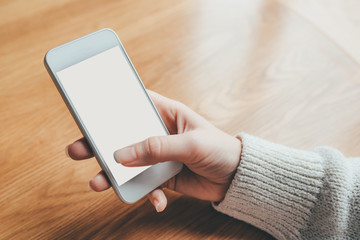 Woman's hand holding phone with white screen. Copy space for your text message.