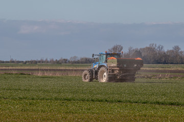 Obraz premium tractor fertilizer in a field , countryside