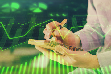 Double exposure hands with stock market chart.