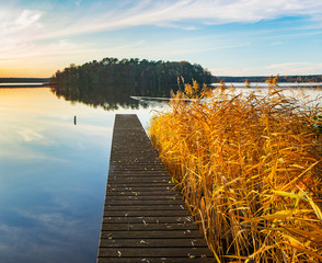 Stiller See im Herbst, Steg und Schilf im Abendlicht, Brandenburg, Deutschland