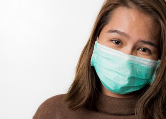Asian young woman wearing a hygiene protective mask over her face on white background, protect from...