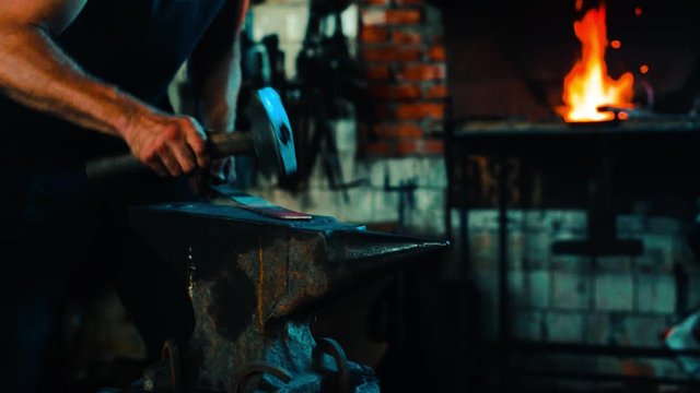 Blacksmith forge sword blank on anvil and fire in the furnace on background