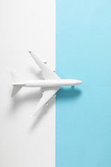 White model plane. Airplane on pastel blue and white background. Travel vacation concept. Flat lay, top view, copy space