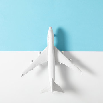 White model plane. Airplane on pastel blue and white background. Travel vacation concept. Flat lay, top view, copy space
