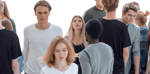 serious woman standing in front of casual group of young people
