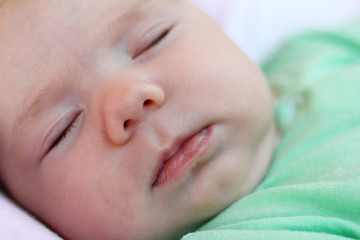 Portrait of infant little girl sleeping in her bed at home.
