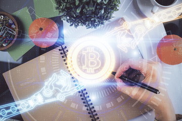 Cryptocurrency hologram over woman's hands writing background. Concept of blockchain. Multi exposure