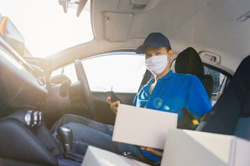 Asian Delivery man wearing mask send a package holding smartphone on front receiver shipping deliver cargo social distancing, Many parcel in hatchback car while the virus is spreading medical concept.