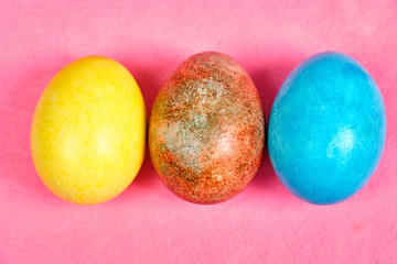 Multicolored, painted Easter eggs on a pink background. space for text