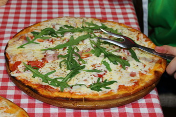 Ham, mozzarella and arugula pizza