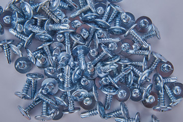 Steel screws in large quantities on a white background