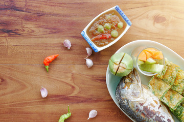 Top view The shrimp Paste, Mackerel, vegetable and Omelet with Climbing Wattle, Acacia or Cha-om on the wooden table back ground.Vintage filter.
