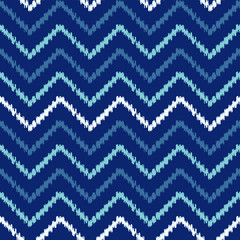 Abstract chevron Ikat geometric seamless pattern. Blue scribble zigzag waves on dark background. Ethnic asian, indian, aztec fashion style. Fancy boho texture for fabric print, wallpaper, gift wrap.