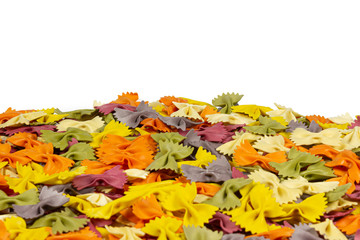 Italian raw multicolored farfalle pasta on white background with copy space. Colorful pasta in bow tie shape. Italian cuisine concept. Mockup for design.